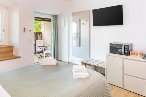 a white room with a bed and a tv on the wall at L'angolo del Forte in Rivoli Veronese