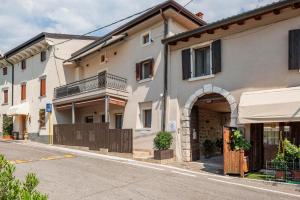 an apartment building with an archway in a street at L'angolo del Forte in Rivoli Veronese
