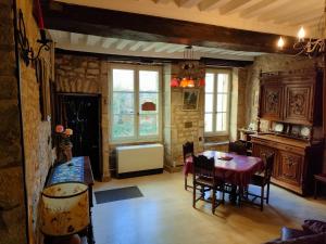 a dining room with a table and chairs in a building at MUSIROSA in Vézelay