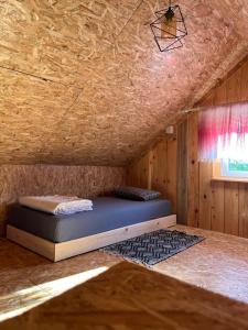 ein Bett in einem Zimmer mit Holzdecke in der Unterkunft Dva Bora Holiday Home in Banja Luka