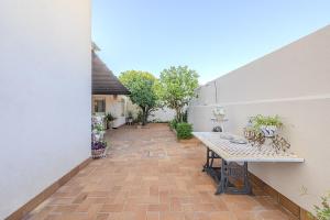 an outdoor patio with a table on a brick floor at De la Danza in Seville