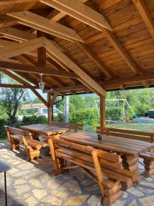 ein Holzpavillon mit Holztischen und einem Spielplatz in der Unterkunft Dva Bora Holiday Home in Banja Luka