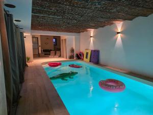 a swimming pool with three frisbees on top of it at L oasis de Détente - le Cocon - gîte 4 personnes avec 1h d accès à la piscine privée et terrasse aménagée par nuit réservée - climatisation - à 2km de Pairi Daiza in Brugelette