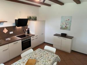 a kitchen with white cabinets and a table and a sink at Haus Fünfschläfer in Dreschvitz