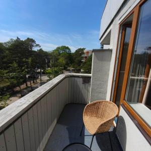 a balcony with a chair and a view of a street at Alka guest house in Palanga