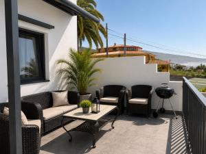a patio with chairs and a table on a balcony at Atlantic View Loft - Spa & Sunset in La Orotava