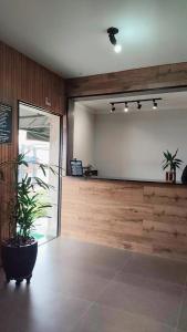 a lobby with a large mirror and a potted plant at Uniflat Hotel Bauru in Bauru