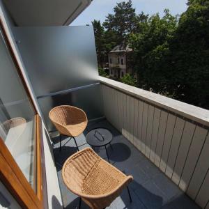 a balcony with two chairs and a table on it at Alka guest house in Palanga