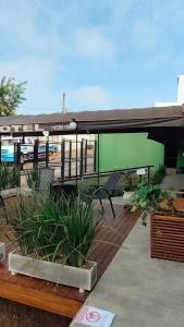 a patio with a green building with a table and chairs at Uniflat Hotel Bauru in Bauru