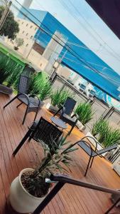 a patio with chairs and a potted plant on a deck at Uniflat Hotel Bauru in Bauru +11 photos