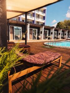 a bed sitting on a deck next to a swimming pool at White Villas Koblevo in Koblevo