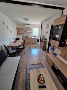 a living room with a table and a dining room at Apartment Lela - self check-in and check-out in Otočac