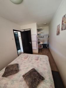 a bedroom with a bed with two pillows on it at Apartment Lela - self check-in and check-out in Otočac