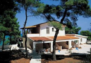 a house with a porch and a person sitting on the balcony at Sfinal Residence in Peschici
