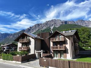 a house with a fence in front of a mountain at Bormio BM0 - Tutta Bormio a Zero stress in Bormio