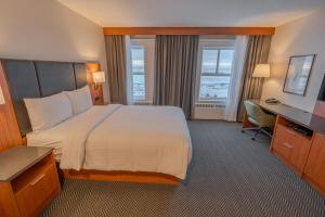 a hotel room with a large bed and a desk at The Frobisher Inn in Iqaluit +19 photos