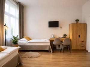 a room with two beds and a table and a tv at Gdańsk in Gdańsk