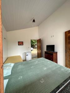a bedroom with a bed and a television in it at Nosso Chalé in Marapanim