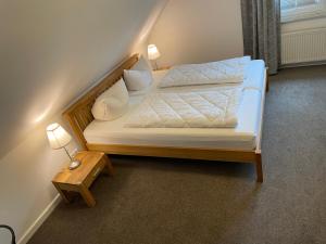 a bedroom with a bed with two pillows and a table at Haus Fünfschläfer in Dreschvitz
