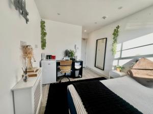a bedroom with a bed and a desk and a kitchen at The Grove Sutton in Sutton