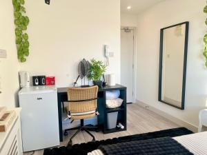 a room with a desk with a chair and a mirror at The Grove Sutton in Sutton