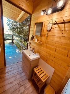 a bathroom with a sink and a wooden wall at Les Lodges de l'Etang in Roquebrune-sur-Argens