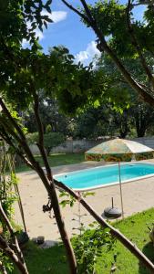 a swimming pool with an umbrella and a beach at A Casa da lua in Lagoa Santa +16 photos