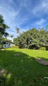 a field of grass with a house and a palm tree at A Casa da lua in Lagoa Santa