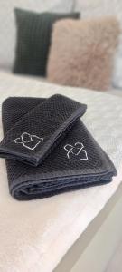 two black towels sitting on top of a bed at Tiny house U Lasiček in Perštejn