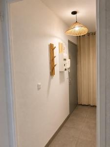 a hallway with a white wall with a light fixture at Charmant studio,Terrasse et Parking in Montpellier