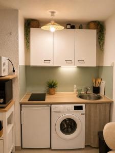 a kitchen with a washing machine and a sink at Charmant studio,Terrasse et Parking in Montpellier