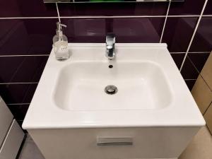 a white bathroom sink with a soap bottle on it at Charmant studio,Terrasse et Parking in Montpellier