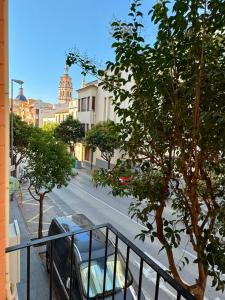 a balcony with a car parked on a city street at El Hostalito in Ontinyent