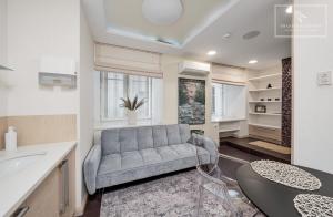 a living room with a couch and a table at Boutique Flat - Spa Shower - Sound System in Tallinn
