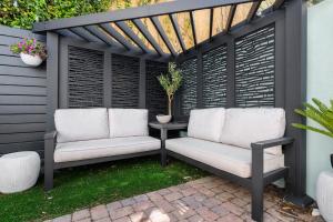 a pergola with two white chairs on a patio at Downtown CHS King Beds Convert to Singles in Charleston