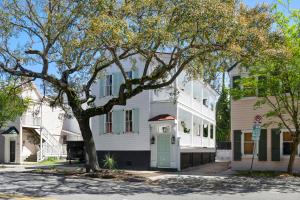 a white house with a green door on a street at Downtown CHS King Beds Convert to Singles in Charleston