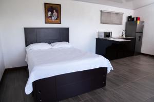 a bedroom with a large bed and a kitchen at Cabaña El Sargento in San Francisco
