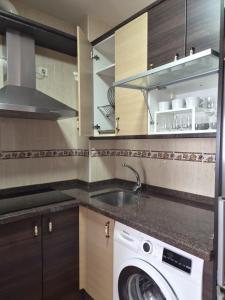 a kitchen with a sink and a washing machine at Apartamento click center in Ronda