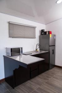 a kitchen with a sink and a refrigerator at Cabaña El Sargento in San Francisco +49 photos