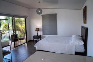 a bedroom with a white bed and a balcony at Cabaña El Sargento in San Francisco