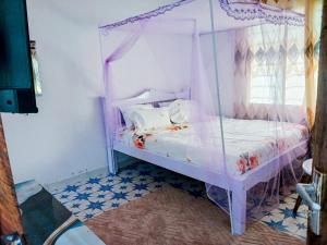 a bedroom with a bed with a canopy at Diamond luxury Studio Watamu in Watamu