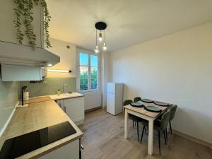 a kitchen with a small table and a kitchen with a sink at L'Echappée Belle in Paray-le-Monial +12 photos