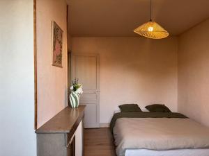 a bedroom with two beds and a vase of flowers at L'Echappée Belle in Paray-le-Monial