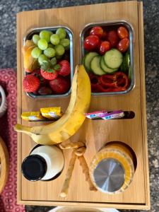 a wooden tray with fruits and vegetables and a banana at Obytňák Bohoušek in Pulečný