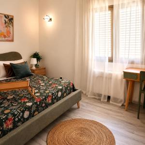 a bedroom with a bed and a desk and a window at La Via Per Erice in Casa Santa