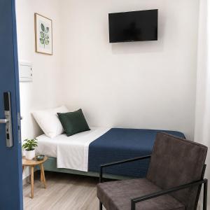 a small bedroom with a bed and a chair at La Via Per Erice in Casa Santa