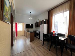 a kitchen and living room with a table and chairs at Noyemberyan Central Apartment in Noyemberyan