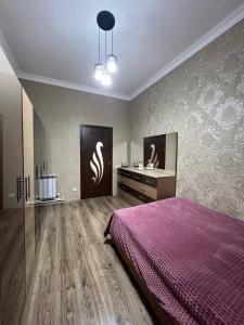 a bedroom with a purple bed and a sink at Noyemberyan Central Apartment in Noyemberyan
