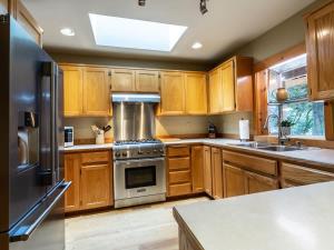 a kitchen with wooden cabinets and stainless steel appliances at Naturbyn Retreat in Glacier