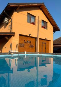 a building with a swimming pool in front of it at Luca Rooms in Curtea de Argeş